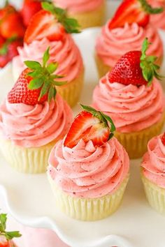 cupcakes with pink frosting and strawberries on top