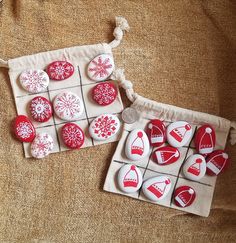 two bags filled with red and white buttons on top of a brown cloth covered surface