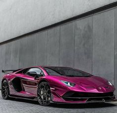 a pink sports car parked in front of a building