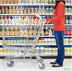 a woman pushing a shopping cart through a grocery store