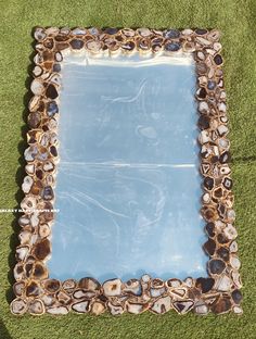 a decorative mirror sitting on top of green grass