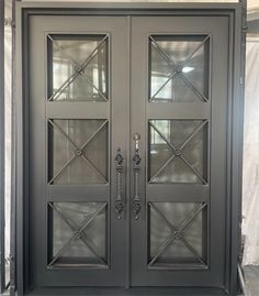 two double doors with glass panels on each side and an iron frame at the top