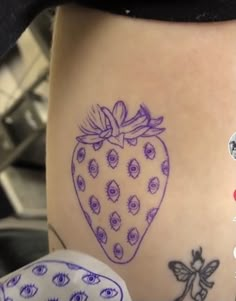 a close up of a person's leg with tattoos on it and a strawberry