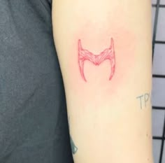 a person with a tattoo on their arm has a red devil's head drawn on it