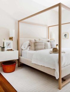 a white bed sitting in a bedroom next to a window