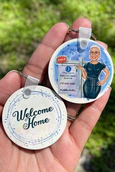 a hand holding a welcome home badge with a woman's face on it and the words welcome home