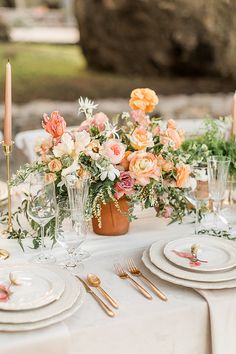 an image of a table setting with flowers in vases and place settings on it