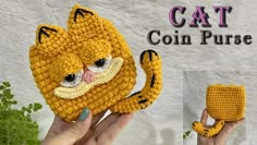 a crocheted cat purse is being held by someone's hand