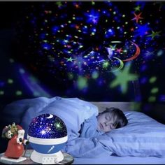 a child is sleeping in bed with the night sky and stars painted on the wall