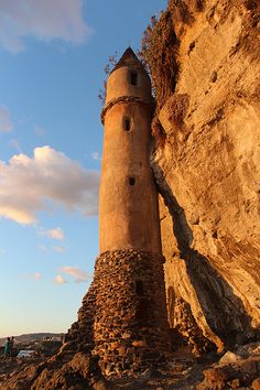 a tall tower sitting on top of a rocky cliff