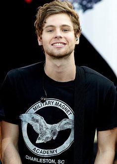 a young man wearing a black shirt with an eagle on it