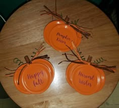 three orange plates sitting on top of a wooden table with happy thanksgiving written on them