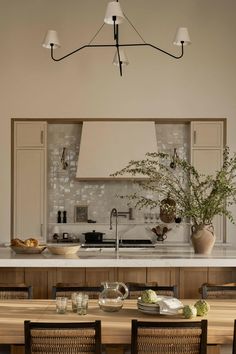 a kitchen with a table and chairs next to an island in the middle of it