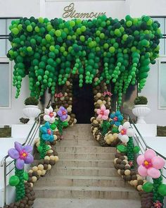 an entrance to a building decorated with balloons and flowers on the steps that lead up to it