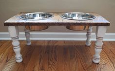 two metal bowls sitting on top of a wooden table