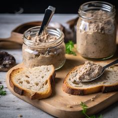 two slices of bread on a cutting board with peanut butter and spoons in the jar