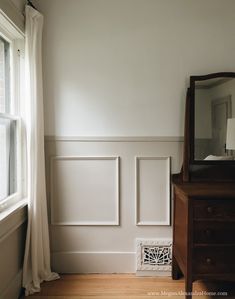 a bedroom with white walls and wood floors