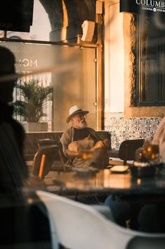 a man sitting at a table in front of a window