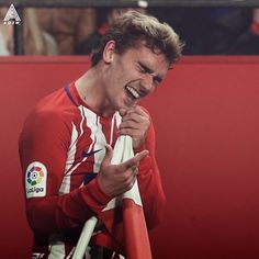 a man is laughing while holding a soccer ball