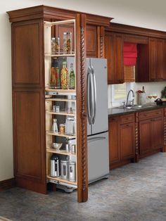 a kitchen with wooden cabinets and stainless steel refrigerator freezer next to an open pantry door