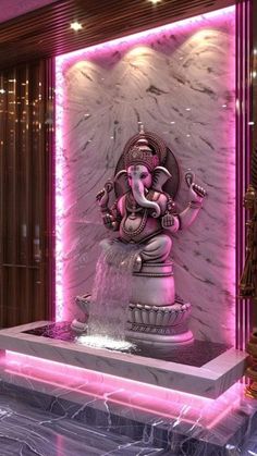 an elephant statue sitting on top of a fountain in the middle of a room with pink lighting