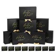 six black boxes with gold lettering and bows