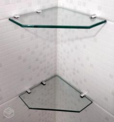 a corner glass shelf in a white tiled bathroom