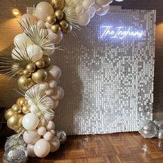 the balloon arch is decorated with gold and white balloons