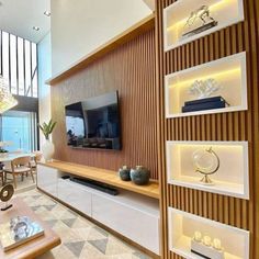 a living room filled with furniture and a flat screen tv on top of a wooden wall