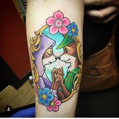 a cat with a hat and flowers on it's head is shown in this colorful tattoo