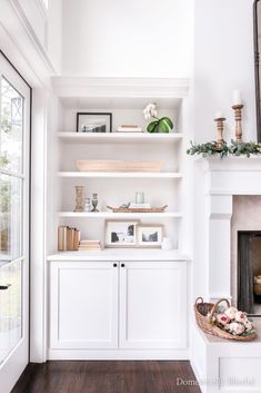 a living room filled with furniture and a fire place in front of a white fireplace