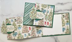 three cards with christmas designs on them sitting on top of a marble countertop next to each other