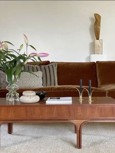 a living room filled with furniture and flowers on top of a coffee table in front of a couch