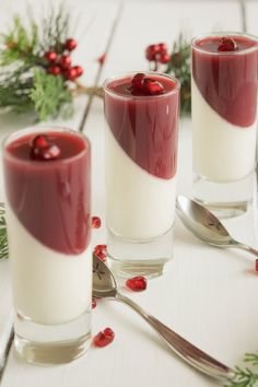 three glasses filled with red and white liquid on top of a table next to silverware