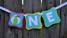 a one banner hanging on a wooden fence