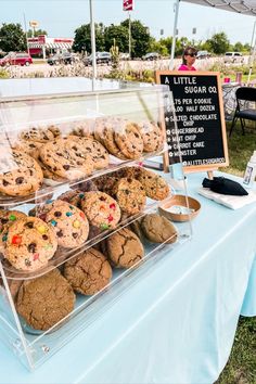 there are many cookies and muffins on display at this outdoor market stall that sells them