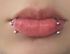 a woman's lips with piercings on them