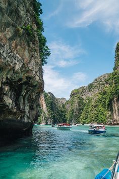 several boats are in the water near some cliffs