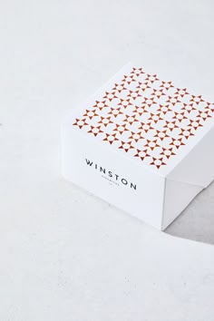 a white box sitting on top of a table next to an orange and black object