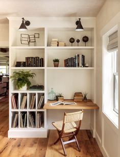 a wooden chair sitting in front of a white book shelf filled with lots of books