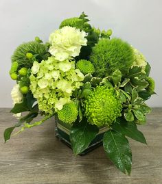 a vase filled with green and white flowers