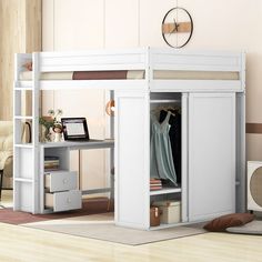 a white loft bed with a desk underneath it and shelves on the bottom floor below