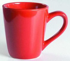 a red coffee cup sitting on top of a white table