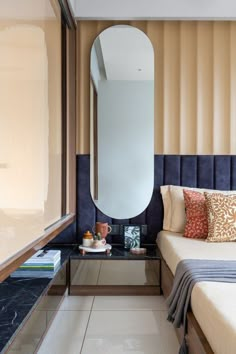 a bed sitting next to a mirror on top of a wall