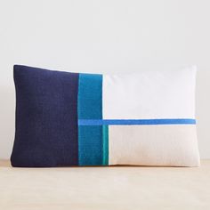 a blue and white pillow sitting on top of a wooden table