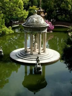 a small white building sitting on top of a pond