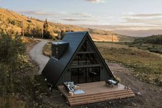 a small cabin in the middle of an open field with stairs leading up to it