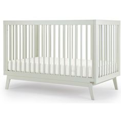 a baby crib with white sheets on it