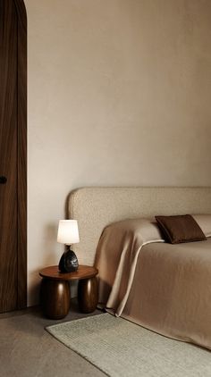 a bed sitting next to a wooden door in a bedroom