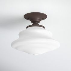 a ceiling light with a white glass shade hanging from it's center point on the ceiling